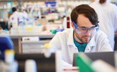 Scientist working on a laptop in a laboratory setting