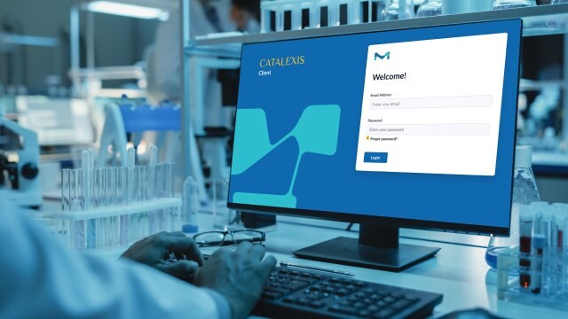 Chemik, który nie jest widoczny, widzi ekran logowania do Catalexis w dobrze wyposażonym laboratorium chemicznym z zaawansowanymi instrumentami.