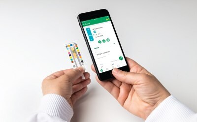 A user glances at the test result of the chemical parameter on MQuant® StripScan App installed on a smart phone